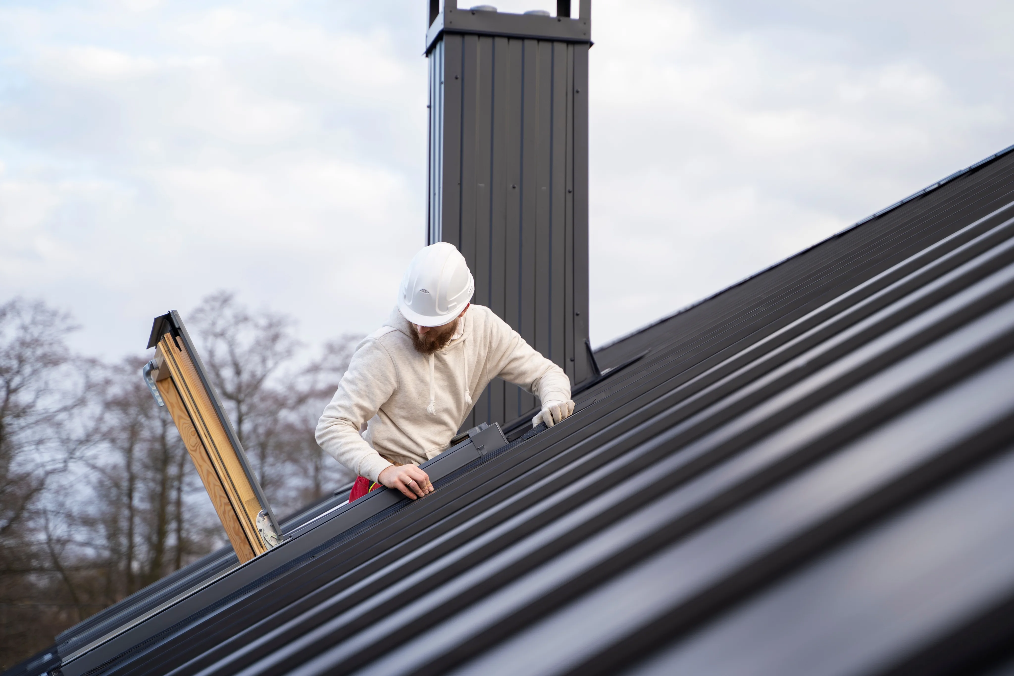 Roofing worker installing a metal roof